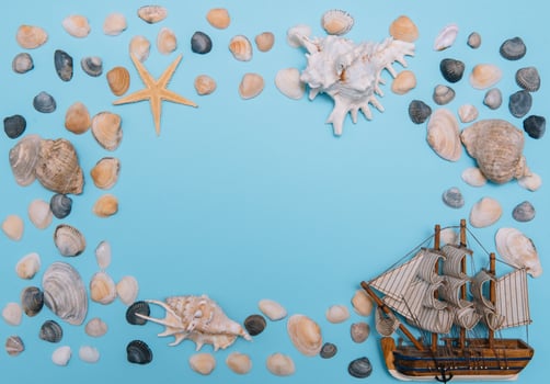 Flat lay. Top view. Frame of shells of various kinds on a blue background. Seashells and starfish and ship on a pastel background. Vacation concept. travel concept. with copy space photo