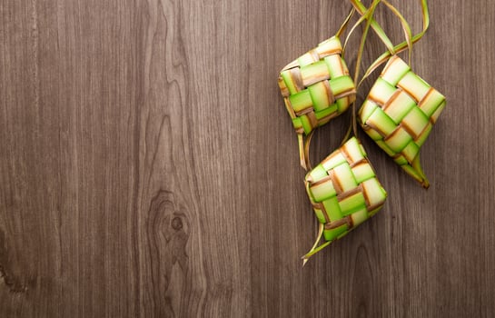 Kelongsong Ketupat decoration on wooden table. photo