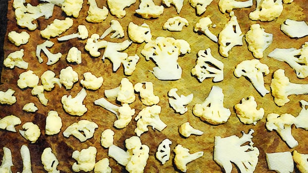 A baking pan filled with cauliflower flowers to roast and dress with salad. photo