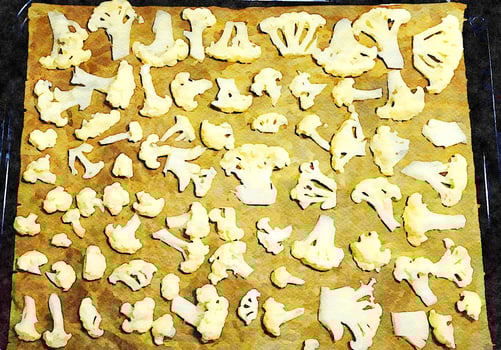 A baking pan filled with cauliflower flowers to roast and dress with salad. photo