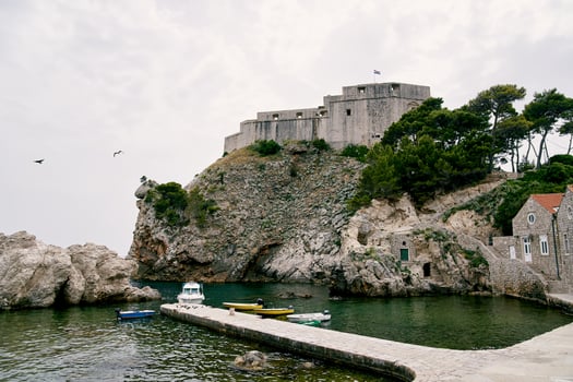 Boats are moored in a small bay near the fortress wall. Dubrovnik, Croatia photo