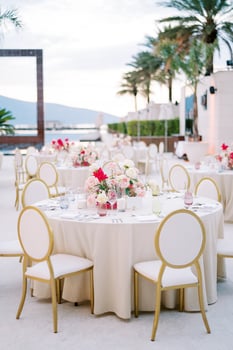 Chairs stand around a set festive table with bouquets of flowers photo