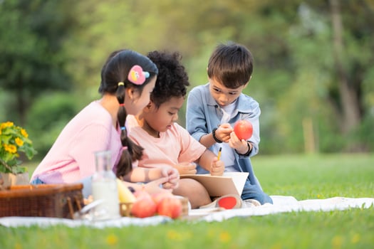 Happy family enjoying a picnic in the park, Children are having fun drawing on paper. photo