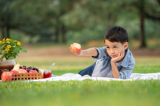 Happy family enjoying a picnic in the park, with children having fun sitting, surrounded by nature photo