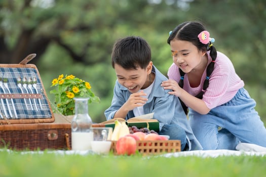 Happy family enjoying a picnic in the park, Children sitting and reading books. photo