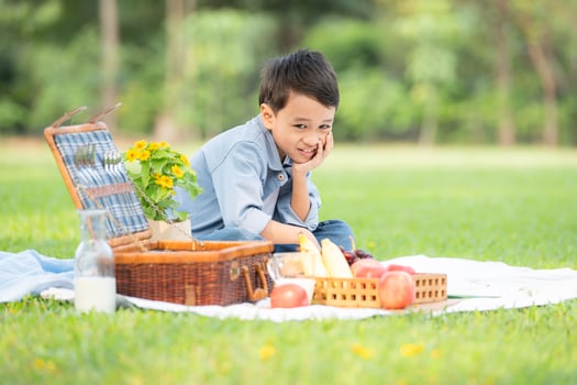 Happy family enjoying a picnic in the park, with children having fun sitting, surrounded by nature photo