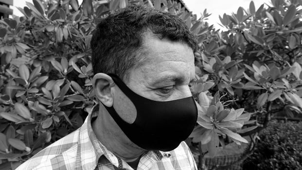image that portrays the face of a man with a black protective anti-contagion mask photo