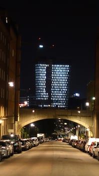A street in the center of Stockholm during the night. From a distance you can see the lights of a modern building. photo