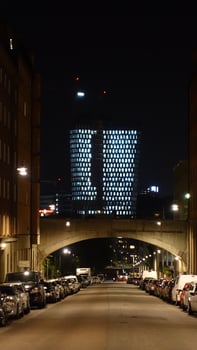 A street in the center of Stockholm during the night. From a distance you can see the lights of a modern building. photo
