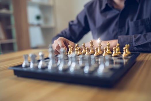 Strategic contemplation in action with a person making a chess move, focus on the golden and silver pieces. Business strategy success concept photo