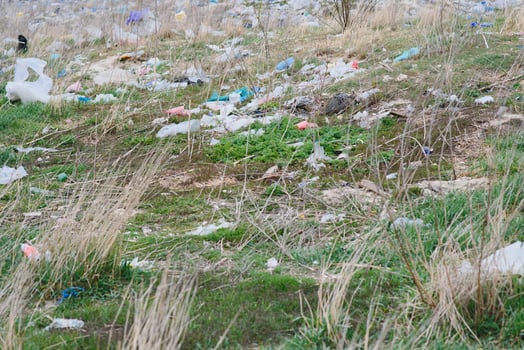 Ecological pollution of nature. Plastic bag tangled in plants against the backdrop of the mountains. Global environmental pollution. Recycling, clearing the land from plastic debris. photo