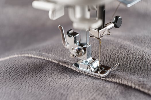 Modern sewing machine with gray velours fabric close up photo