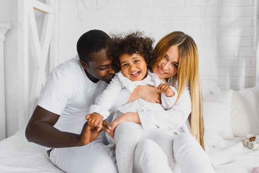 Family laying down together in a bed photo