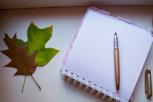 Opened notebook and pen on white table, close up. photo