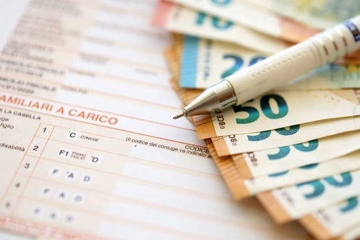 Filling italian tax form process with pen and euro money bills close up. Tax paying period photo