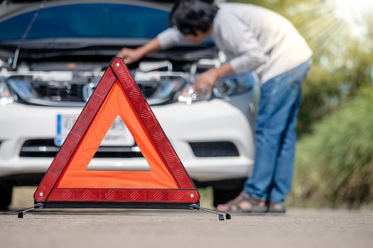 Emergency stop sign and driver near broken car on road. photo