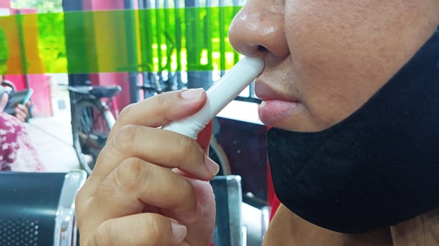 Semarang, Indonesia - March, 2024 - Asian woman using nasal stick inhaler photo