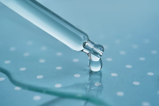Pipette with serum on a blue background. photo