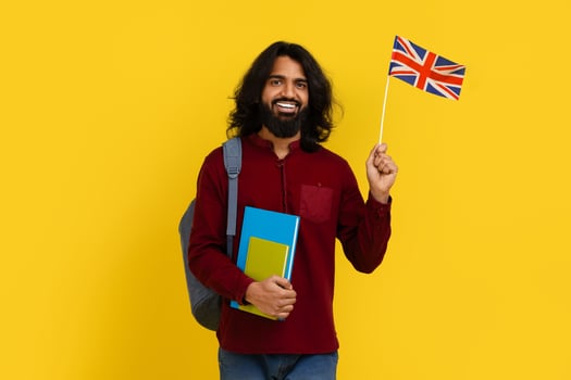 Smiling indian guy student showing flag of Great Britain photo