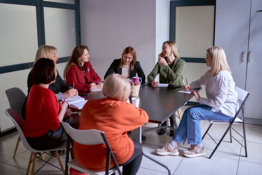 a team of seven women is holding a meeting in the office photo