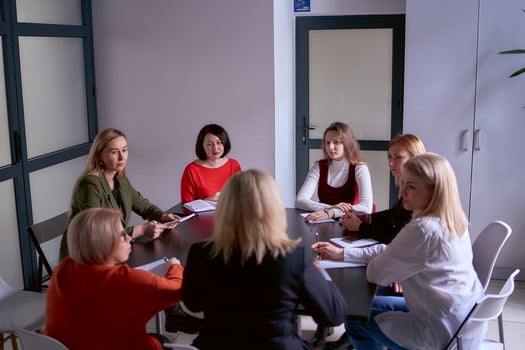a team of seven women is holding a meeting in the office photo
