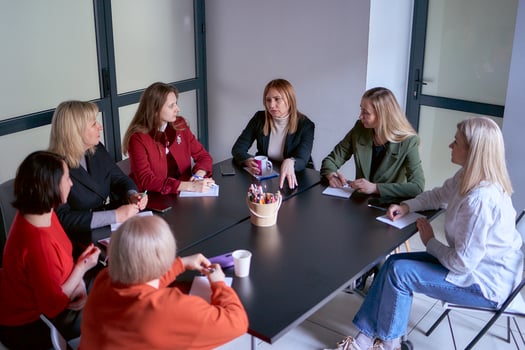 a team of seven women is holding a meeting in the office photo
