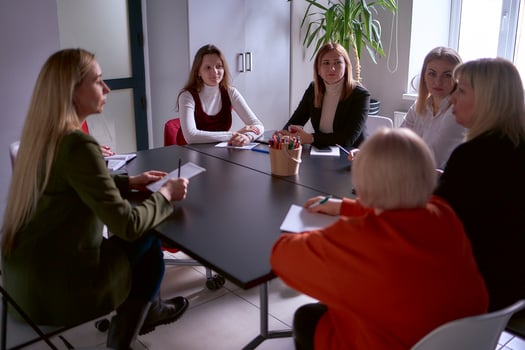 a team of seven women is holding a meeting in the office photo