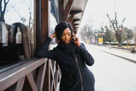 cheerful african woman using smart phone outdoors photo