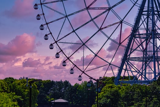 A dusk of ferris wheel at the park behind the blue sky telephoto shot photo