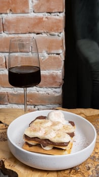 Belgian waffles with bananas, chocolate cream and ice cream on a wooden table in a cafe photo