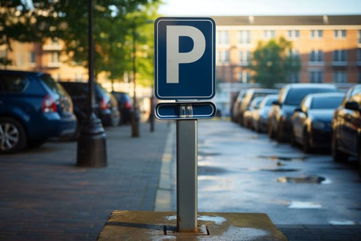 A parking sign stands in front of a row of parked cars in a lot. The vehicles are neatly aligned next to each other in an organized manner. photo