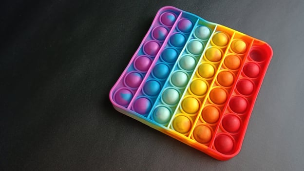 poppit toy on black background, close-up. Colorful poppit it game photo
