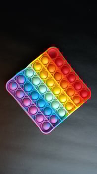 poppit toy on black background, close-up. Colorful poppit it game photo