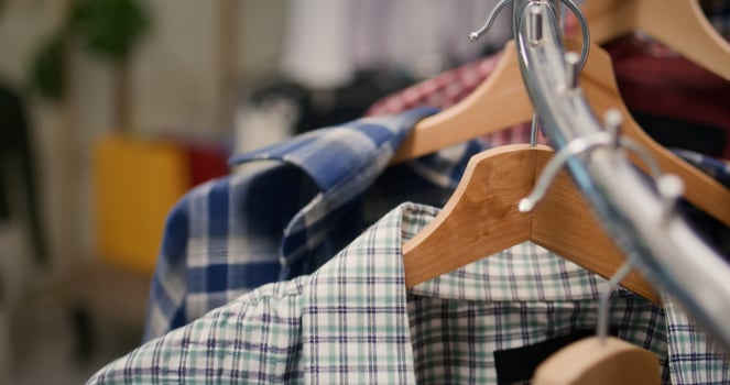 Extreme close up shot of stylish selection of shirts on hangers in high end fashion boutique showcasing trendy garments from new collection. Men shirts rotating on clothing store rack photo