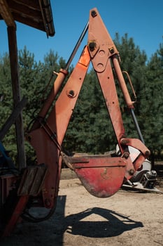 The bucket of the tractor is raised off the ground photo