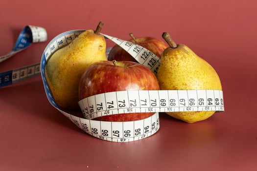 Tape measure and apple symbolizing diet and obesity photo