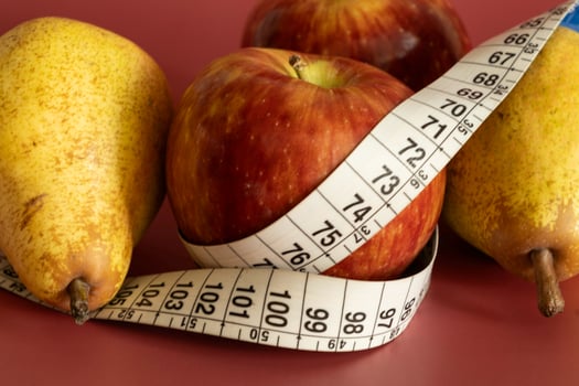 Tape measure and apple symbolizing diet and obesity photo