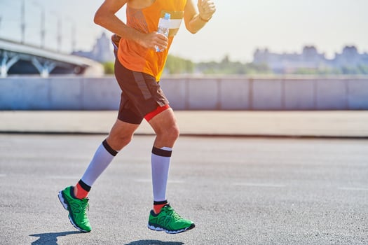 Athletic man jogging in sportswear on city road photo