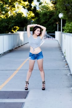 Asian American Woman Standing Outdoors In Jeans Shorts photo