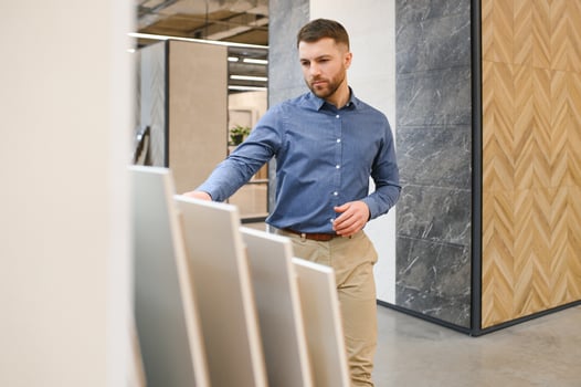 man choosing ceramic tiles and utensils for his home bathroom photo