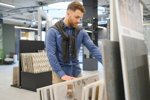Middle age man choosing ceramic tiles and utensils for his home bathroom photo