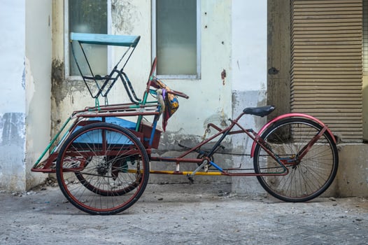 a rickshaw parked on the side of the road. photo