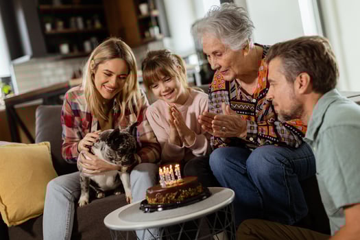 Joyous Family Celebrating Grandmothers Birthday With Cake in a Cozy Living Room photo