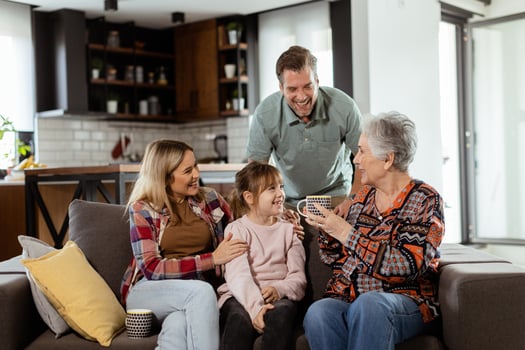 Joyous Family Celebrating Grandmothers Birthday With Cake in a Cozy Living Room photo