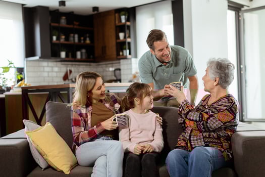 Joyous Family Celebrating Grandmothers Birthday With Cake in a Cozy Living Room photo