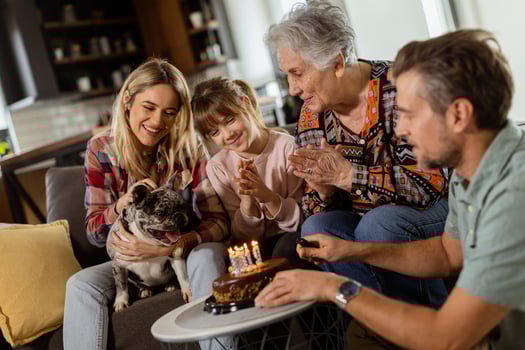 Joyous Family Celebrating Grandmothers Birthday With Cake in a Cozy Living Room photo