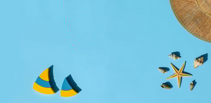 Flat lay banner. Straw hat, yellow-blue wooden boats, sea shells and starfish on blue background. Summer concept. Top view, copy space. Marina style composition. photo