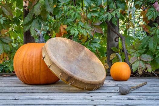 handmade, native American style, shaman frame drum covered by goat skin with pumpkins on a rustic wooden backyard deck photo