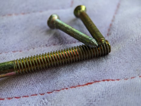 Macro of gold long screw on purple background photo