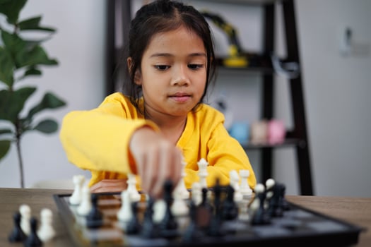 A young girl is playing a game of chess photo